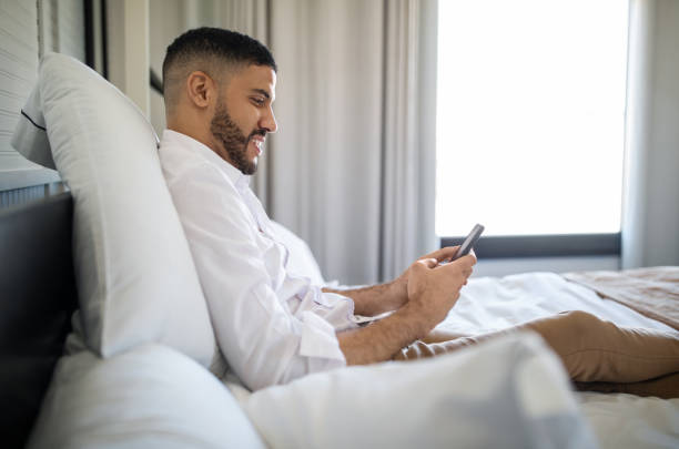 istock Man using his mobile phone in a hotel room 1191193096