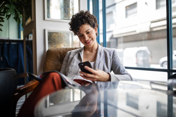 istock Businesswoman using mobile phone while waiting at cafe 1191193133