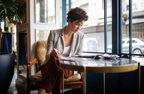 istock Woman reading a magazine at cafe 1191193154