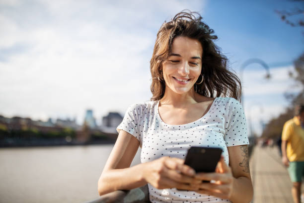 istock Beautiful woman using mobile phone on the boardwalk 1191193167