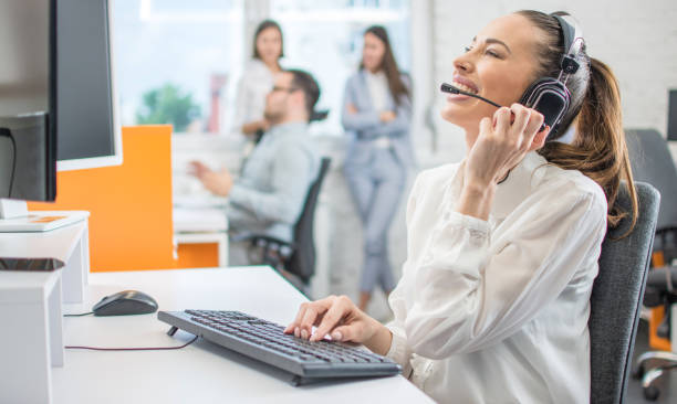 istock Cheerful female customer services agent with headset working in call center 1191194381