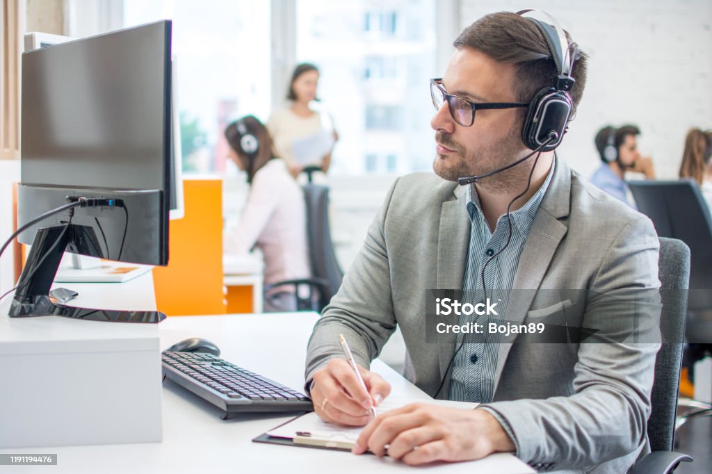 Customer service executive doing some paperwork at office Concentration Stock Photo
