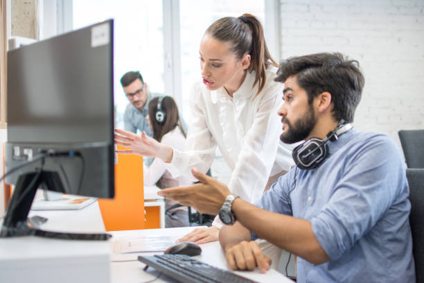 istock Business people discussing project on desktop computer together in office 1191194517