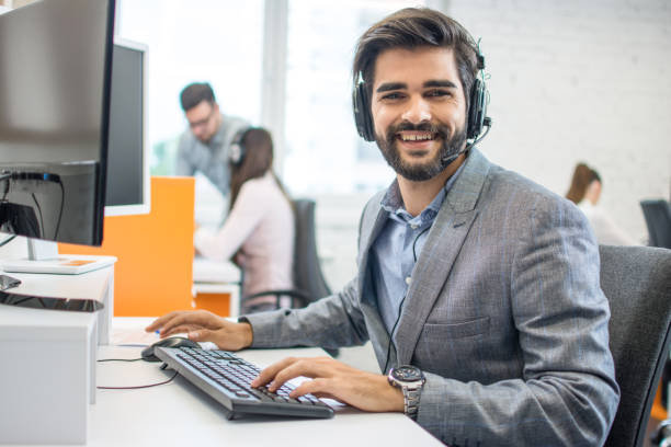 istock Smiling friendly handsome young male call centre operator at office 1191195058
