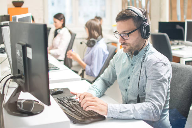 istock Handsome business man with headphones working in call-centre 1191195172