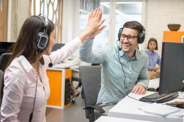 istock Two call center workers giving high five to each other at office 1191195209