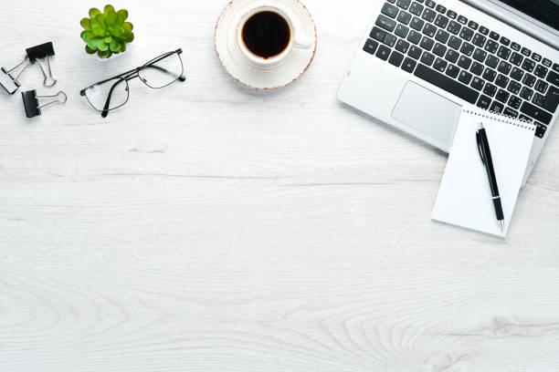 istock White office desk with blank notebook, computer keyboard and office supplies. Top view with copy space, flat lay. 1191195472