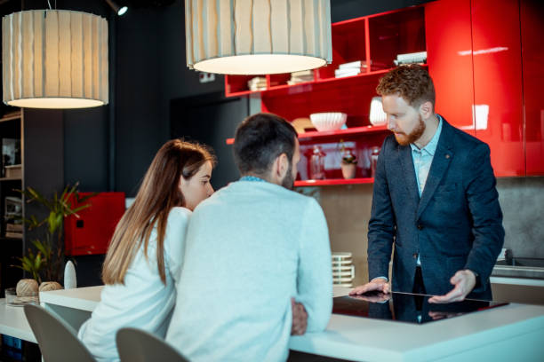 istock Young couple getting advice for kitchen renovation from a sales assistant in a kitchen equipment and accessories store 1191199024