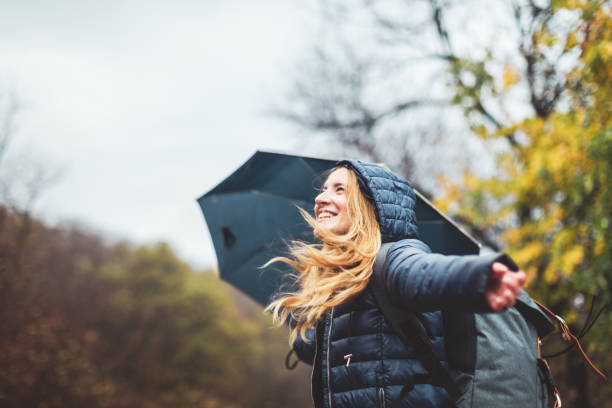 piękna młoda kobieta ciesząc się deszczowy dzień - women winter autumn nature zdjęcia i obrazy z banku zdjęć