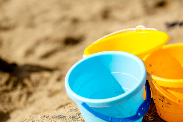 Blue ,orange with yellow buckets on sandbox or yard work and copy space.