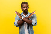 Never again. Portrait of absolutely convinced man crossing hands, showing x sign. indoor studio shot isolated on yellow background