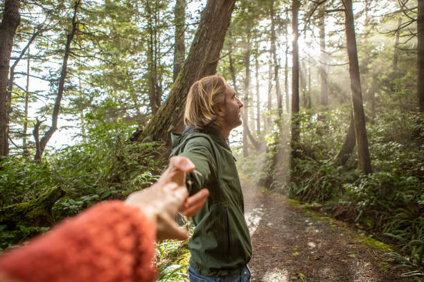 istock Follow me to concept, young man leading girlfriend to forest path; sunlight 1191201245