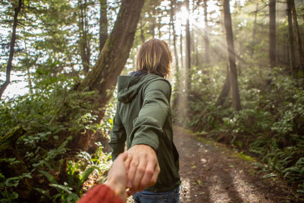 istock Follow me to concept, young man leading girlfriend to forest path; sunlight 1191201246