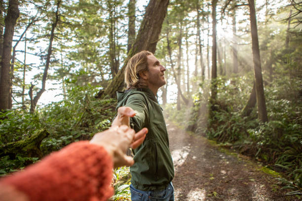 istock Follow me to concept, young man leading girlfriend to forest path; sunlight 1191201311