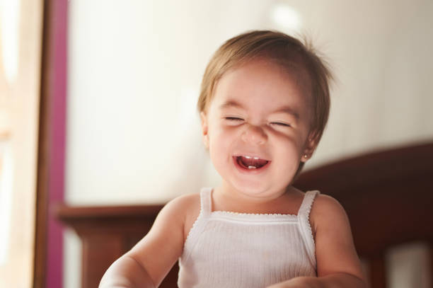 Smiling baby girl looking at camera on the white background.