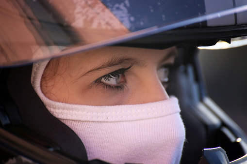 Female race car driver wears helmet and balaclava