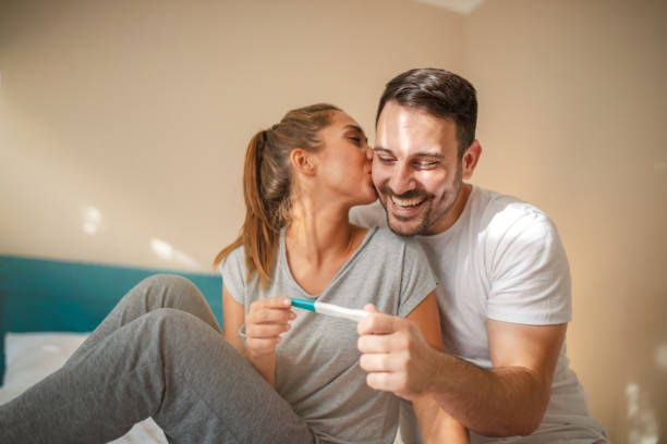 feliz pareja joven con prueba de embarazo - prueba de embarazo fotografías e imágenes de stock