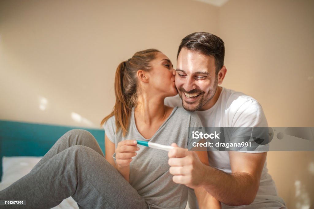 Happy young couple with pregnancy test We become parents. Shot of a couple feeling happy after taking a home pregnancy test.  I'm pregnant! Happy young couple with pregnancy test. Joyful couple with positive pregnancy shown in the test device Pregnancy Test Stock Photo