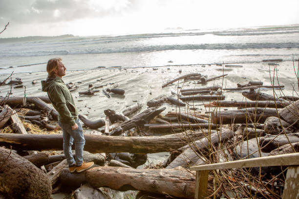 Man looking at the sea from pine tree forest in Canada