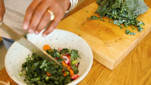 Senior woman making leaf vegetable salad at home
