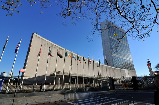 New York，NY，USA-December 1，2011：the United Nations Buildings stand up in the blue sky of Manhattan, attracting lots of tourists from all over the world.