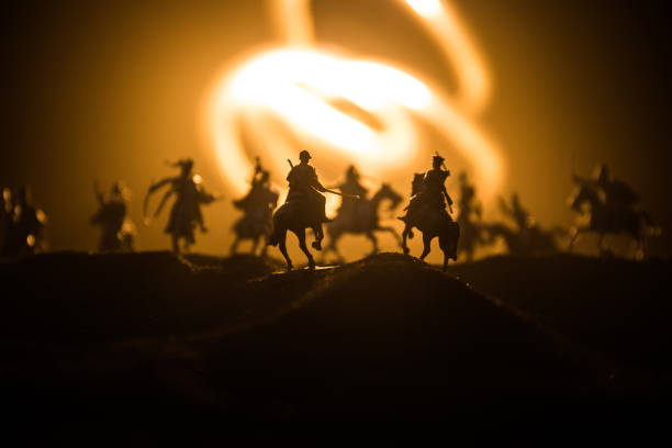 istock Medieval battle scene with cavalry and infantry. Silhouettes of figures as separate objects, fight between warriors on dark toned foggy background. Night scene. 1191214844