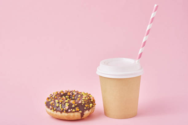 istock Cup of coffee and donut on a pink background 1191216042