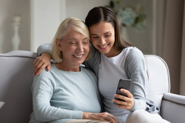 istock Elderly mother and grown up daughter using smartphone making selfie 1191216483