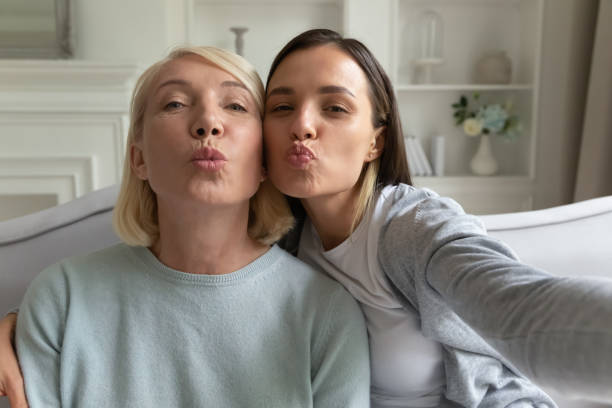 istock Mother and grownup daughter posing making selfie webcam view 1191216534