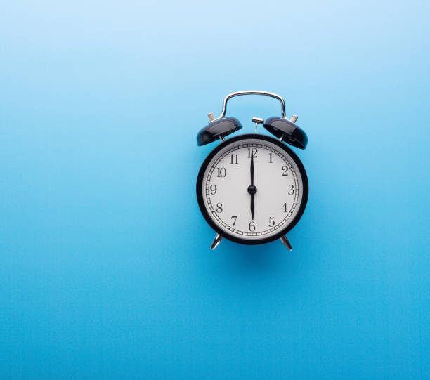 istock Alarm clock on blue background top view. Six o'clock. 1191218281