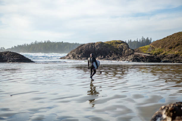 istock Surfer walking out of sea with surfboard 1191219075