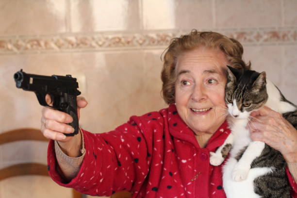 signora esilarante che protegge il suo gatto - fighting female conflict white foto e immagini stock