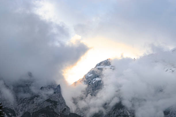 istock Sun behind clouds in european alps 1191221632