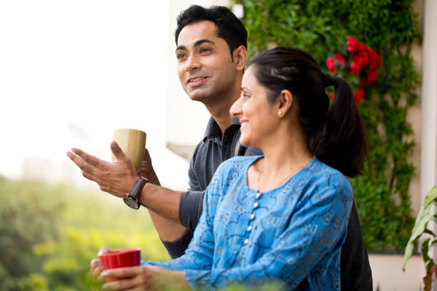 istock Happy couple drinking coffee at balcony 1191222614