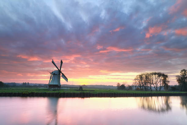 istock dramatic purple sinrise over windmill by river, Holland 1191224999