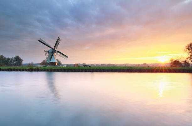 istock beautiful sunrise over river and windmill, Holland 1191225047