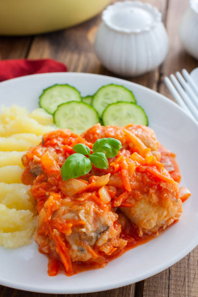 istock Pollock in tomato marinade with onions and carrots on a white plate with mashed potatoes, selective focus 1191225895