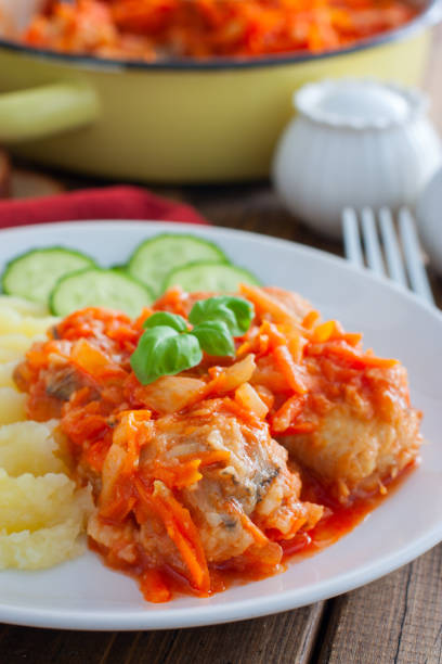 pollock in tomato marinade with onions and carrots on a white plate with mashed potatoes, selective focus - pollock trawler imagens e fotografias de stock