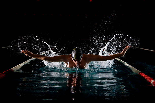 nadador llegar por aire durante la mariposa - butterfly swimmer fotografías e imágenes de stock