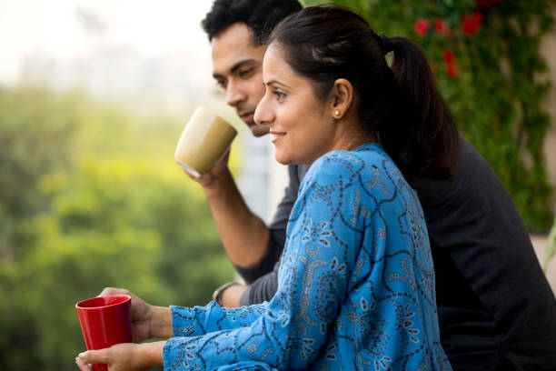 Happy couple drinking coffee at balcony
