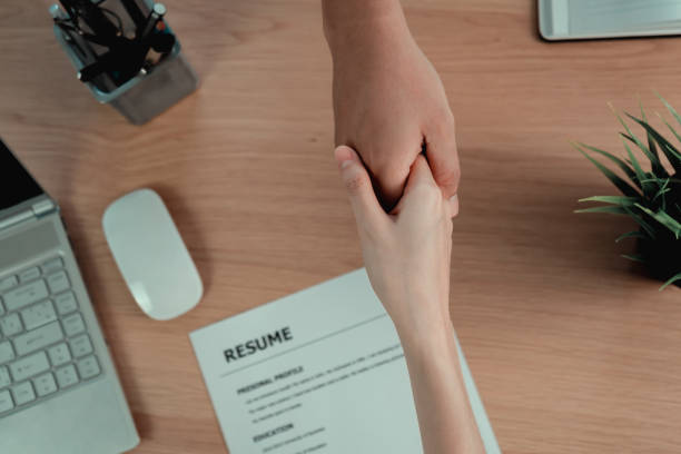 istock Businessman handshake after doing a job interview and reaching an agreement, resume documents on the table 1191233164