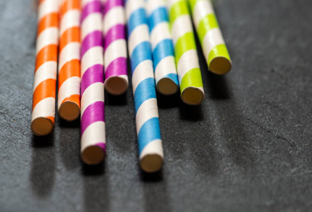 istock Multicoloured drink straws on dark stone background. Vibrant colours contrast on natural light. 1191234242