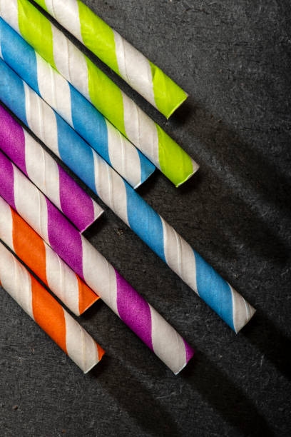 istock Multicoloured drink straws on dark stone background. Vibrant colours contrast on natural light. 1191234261