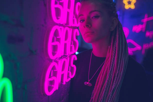 menina em luzes de néon no nightclub, mulher bonita, com cabelo cor-de-rosa longo, com pigtails dos dreadlocks, anos 80 à moda brilhantes, meninas da palavra de néon na parede - dramatic make up - fotografias e filmes do acervo