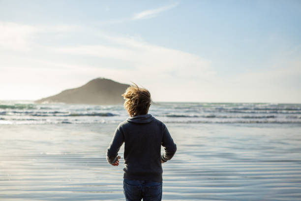 istock Young man running on beach at sunset embracing life 1191235496