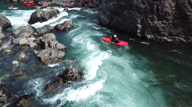 Upside down overturned kayak in white water rapids