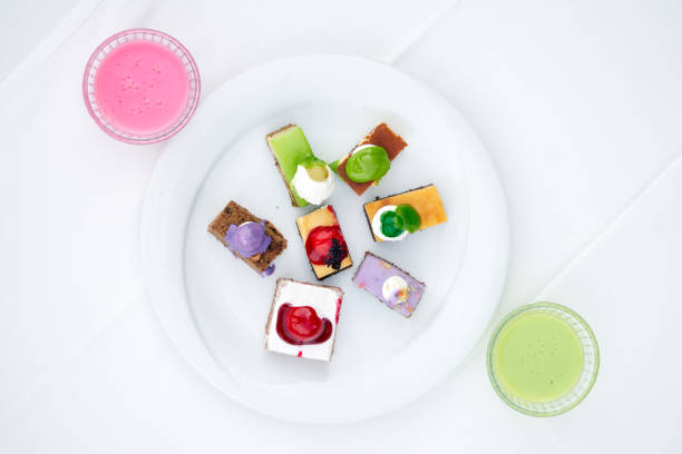 multi-colored biscuit cakes on a white plate with berry mousse in glasses. Celebration, breakfast, baby food. Top view