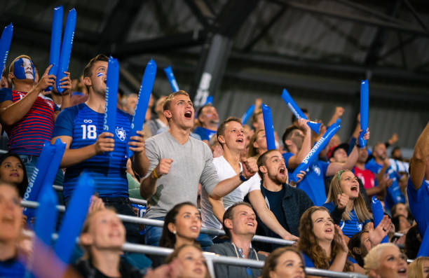 istock Cheering Fans With Blue Banging Thundersticks 1191240081