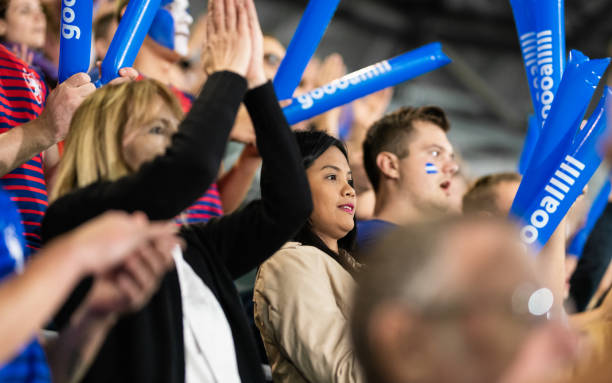 istock Cheering Fans With Blue Banging Thundersticks 1191240082