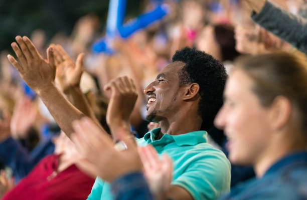 istock Cheering Fans With Blue Banging Thundersticks 1191240091